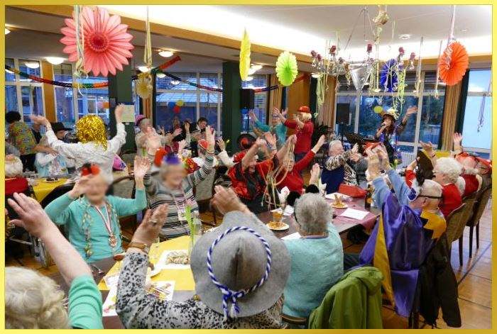 Voller geschmckter Saal mit verkleideten Senioren, die Karneval feiern.Schlagerpiratin singt!