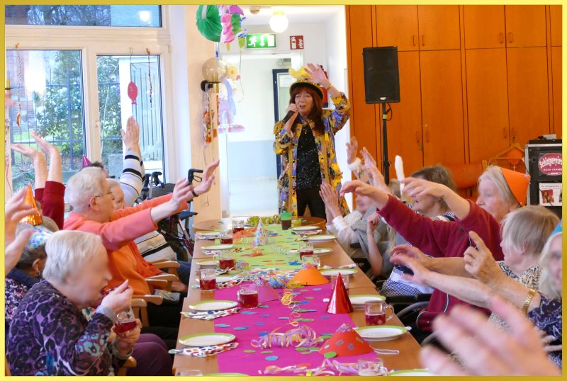 Bunt gedeckter Tisch mit feiernden Senioren.