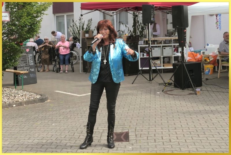 Schlagerpiratin singt beim Sommerfest mit blauer Paillettenjacke.