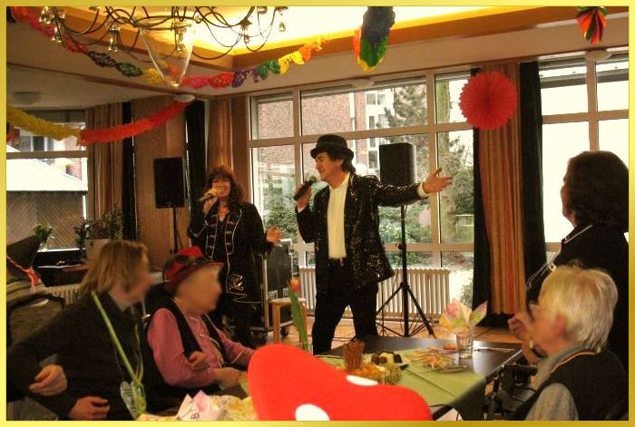 Ian mit Hut und Schlagersngerin Marina singen gemeinsam im geschmckten Karnevals-Saal!
