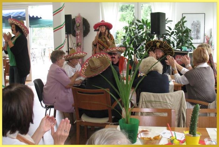 Die Sängerin mit Poncho und Sombrero beim mexikanischen Seniorennachmittag. Auch die Gäste tragen Sombreros.